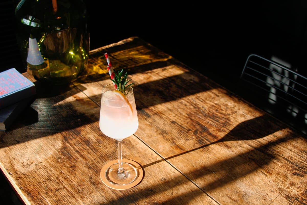 Circolo spritz with a rosemary garnish on a sunlit timber table