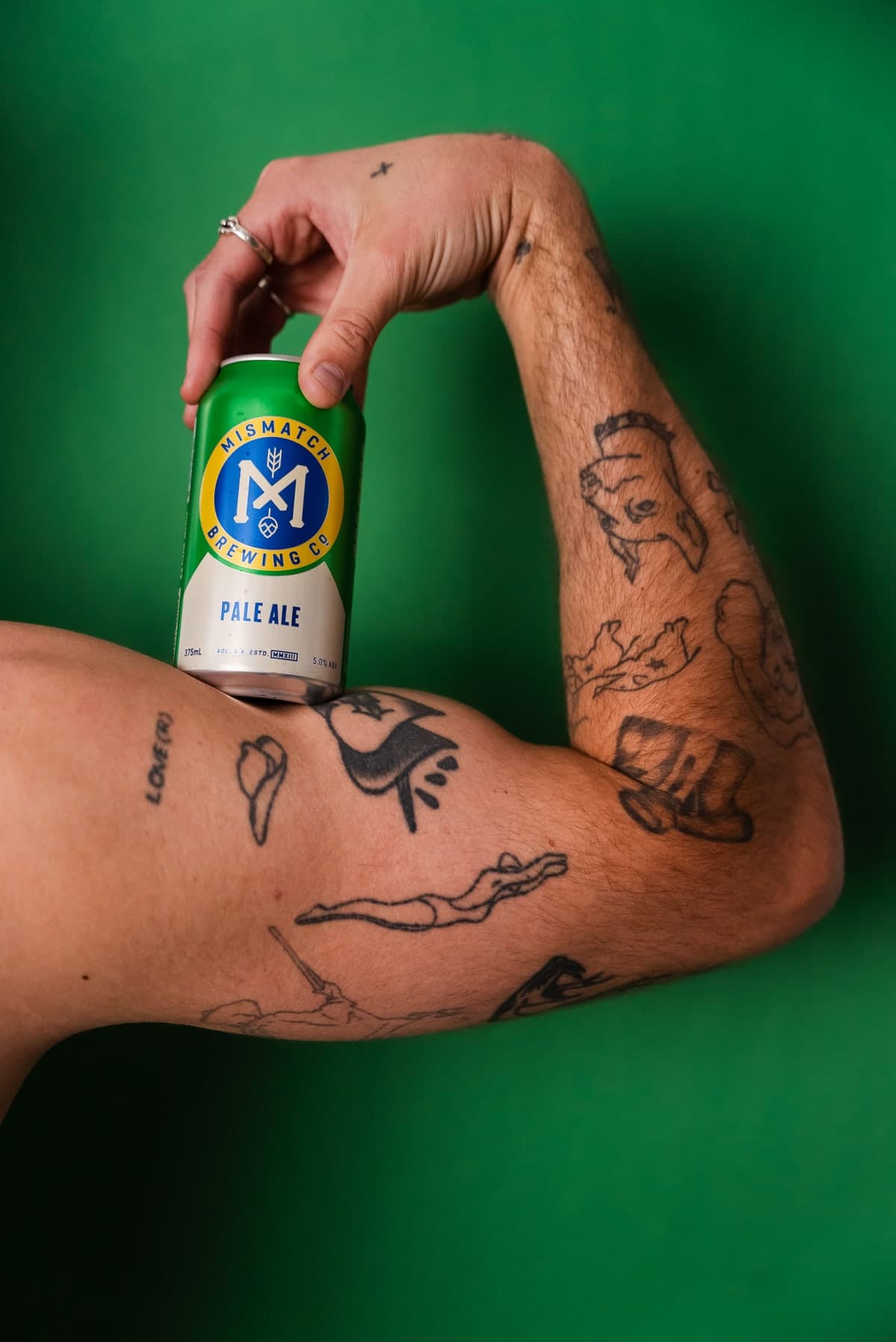 Mismatch Pale Ale can held against a green backdrop